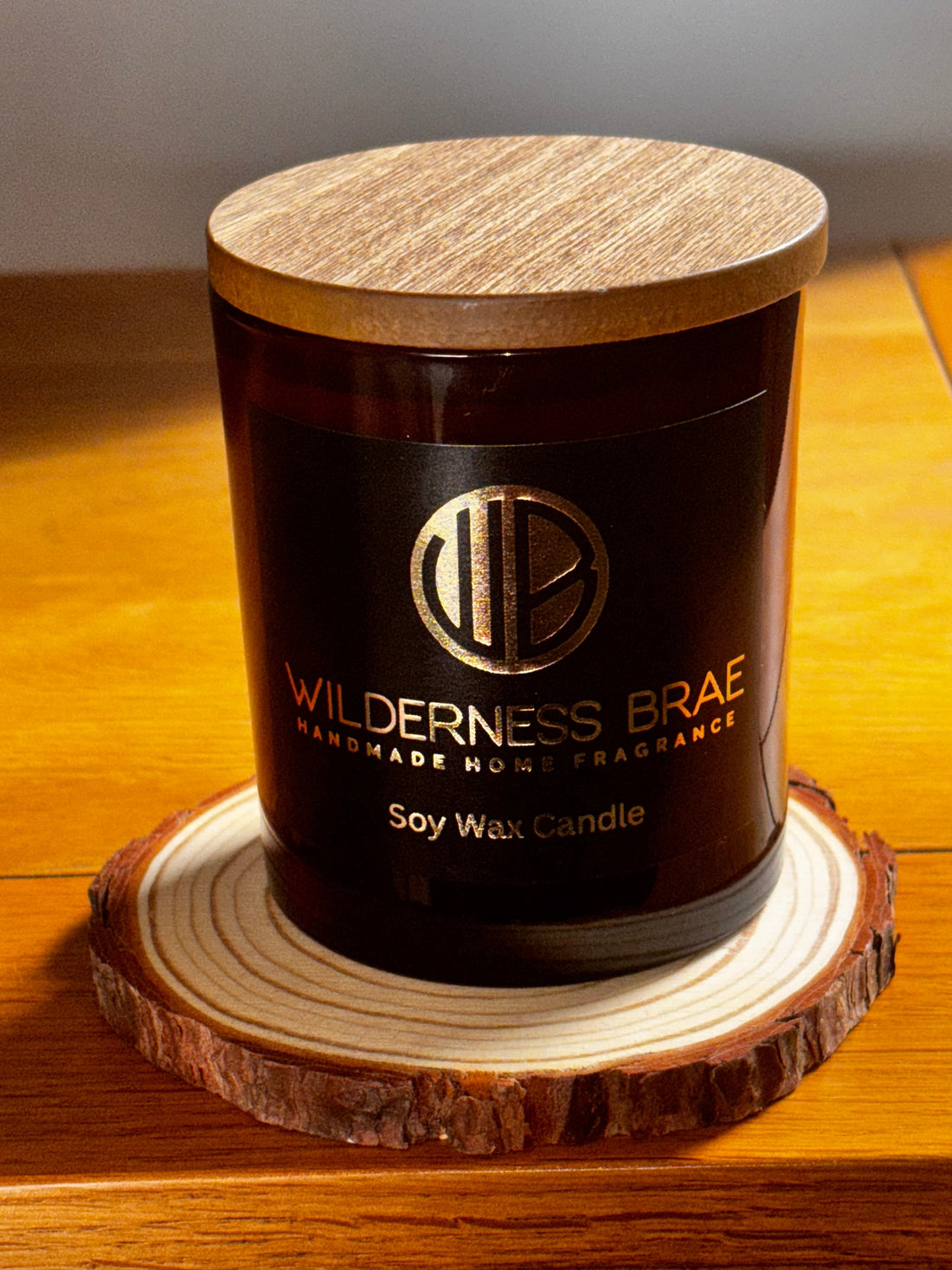 wilderness brae amber glass container candle with wooden lid on log coaster