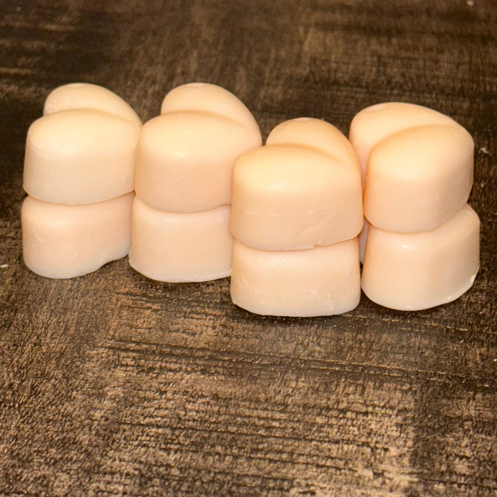 Stack of 8 cream soy wax melts on a textured brown surface