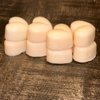 Stack of 8 cream soy wax melts on a textured brown surface