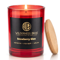 Snowberry Glen soy candle, handcrafted in Scotland by Wilderness brae.  Red glass jar candle with a black and gold label lit with a wooden lid leaning against it on a white background.