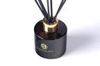 Black diffuser bottle with gold cap on a white background