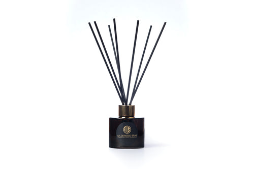 Black reed diffuser with brand logo on a white background