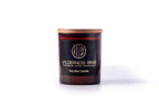 Amber jar with black & gold logo and wooden lid on white background 
