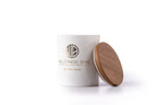 White jar with wooden lid resting against it on white background

