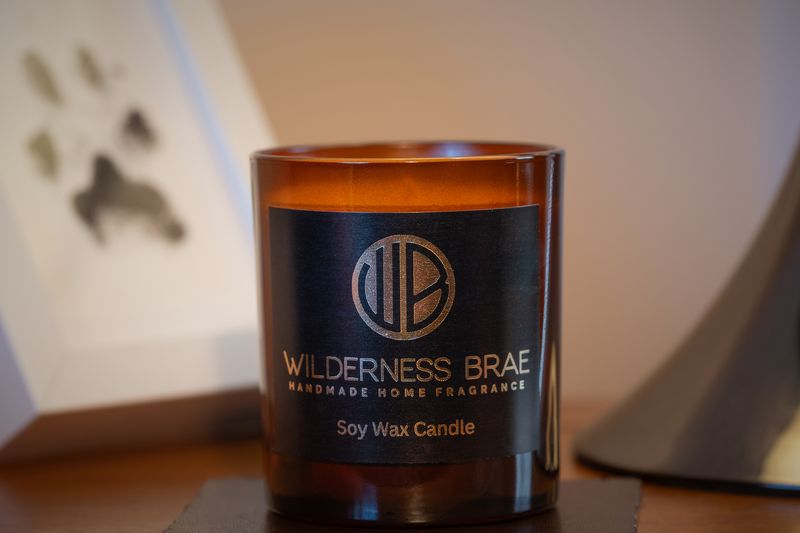 Amber jar with black and gold logo on wood table 